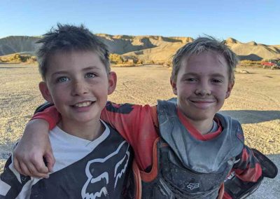 Picture of two kids with dirt on their faces from riding motorcycles