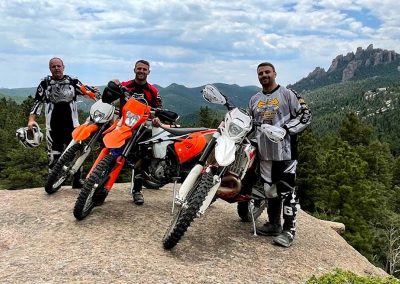 Ktm and Husqvarna enduro riders atop massive granite rock at Rampart Range.