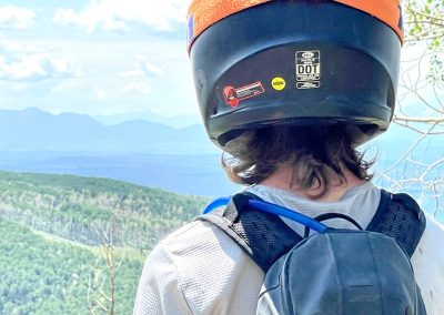 Picture from over the shoulder of enduro rider looking off plateau towards Telluride