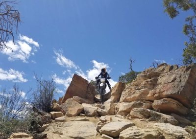 Rider slowly creeps down steep rocky nook atop a ridge above the Black Canyon.