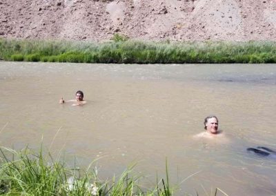 Dirtbikers chill out in a river trying to cool off from the heat of Peach Valley.