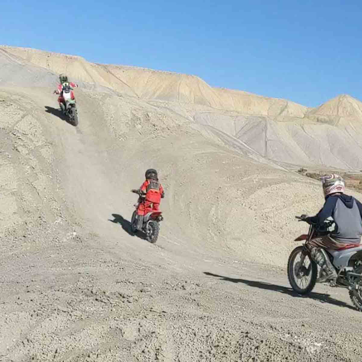 3 kids riding dirtbikes up the adobe hills at Peach Valley OHV